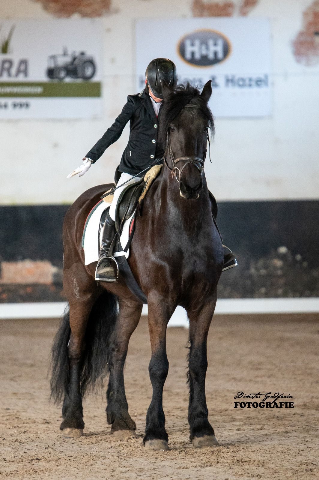 Amazone groet op een zwart paard